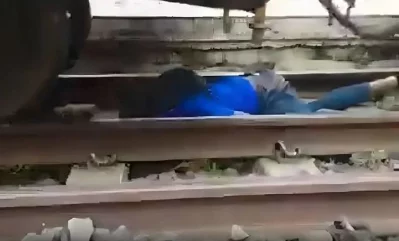 ট্রেনের নিচ শুয়ে আছে কিশোর। ছবি: সংগৃহীত
